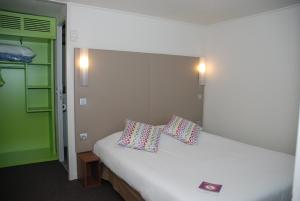 a bedroom with a white bed with two pillows on it at Campanile Creil - Villers-Saint-Paul in Villers-Saint-Paul