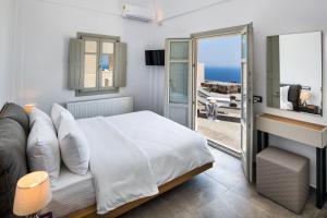 Un dormitorio con una cama y vista al mar. en Theano Cave Suites & Villas, en Imerovigli