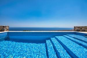 una piscina con el océano en el fondo en Theano Cave Suites & Villas en Imerovigli