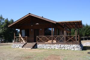 Cabaña de madera con porche y escalones para acceder a ella en Cabaña Aroma de Campo, en Villarrica