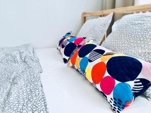 Rich & Poor Hostel Albufeira في ألبوفيرا: غرفة نوم مع سريرين توأم مع وسائد ملونة