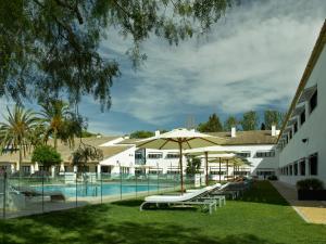 a hotel room with a pool and lawn chairs at Parador de Antequera in Antequera