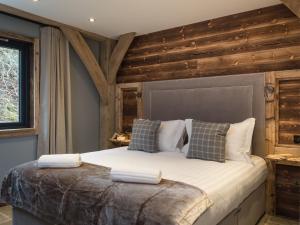 a bedroom with a large bed with wooden walls at Cairngorm Lodge in Aviemore