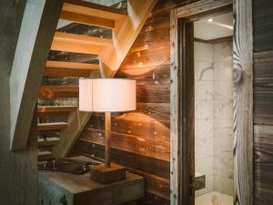 - une lampe sur une table dans une chambre dotée de murs en bois dans l'établissement Cairngorm Lodge, à Aviemore