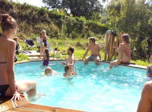 un groupe de personnes assises dans une piscine dans l'établissement Domaine de la Jordanne - B&B, à Saint-Cirgues-de-Jordanne