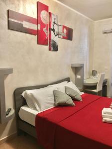 a bedroom with a bed with a red blanket at Residenza Dama in Santa Domenica