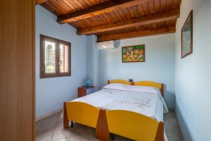 a bedroom with a yellow bed and a window at Villa Stefy in Avola +63 photos