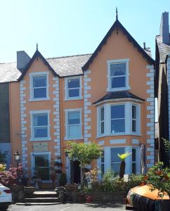 a house with blue windows on a street at Min y Don Guest House in Llanfairfechan