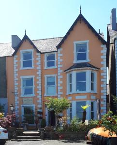 una casa con ventanas azules en una calle en Min y Don Guest House, en Llanfairfechan
