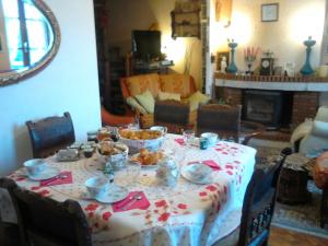 una mesa de comedor con un mantel con comida. en La Longère des Gillettes, en Bézenet