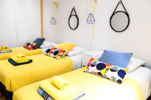 Zimmer mit 3 Betten, Handtüchern und Spiegeln in der Unterkunft Le Sureau in Avignon