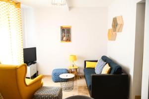 ein Wohnzimmer mit 2 Stühlen und einem blauen Sofa in der Unterkunft Le Sureau in Avignon