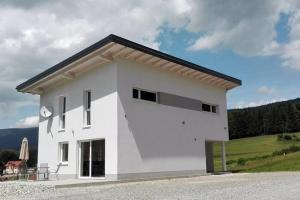 a white house with a black roof at Ferienhaus Grobauer II in Schwarzenberg am Bohmerwald