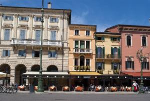 a group of buildings with tables and chairs in a street at City Centre Rooms and Apartments in Verona