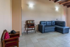 a living room with a blue couch and a tv at Villa Stefy in Avola