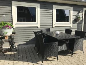 einen schwarzen Tisch und Stühle auf einer Terrasse in der Unterkunft Gårdshus i Borgholm, Öland in Borgholm