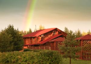 a wooden cabin with a rainbow in the background at AZIMUT Hotel Kostroma in Kostroma