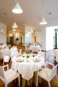 a dining room with white tables and white chairs at Parador de Antequera in Antequera