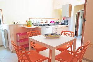 uma cozinha com uma mesa e cadeiras laranja em Casa Elena em Ascea