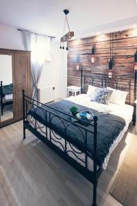1 dormitorio con 1 cama grande y pared de madera en Apartament PREMIUM Blanka en Poronin