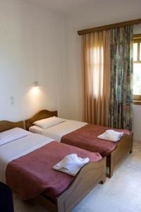 - une chambre avec 2 lits et une fenêtre dans l'établissement Olga Suites, à Maleme