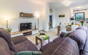 a living room with a couch and a tv at Apartments Tamara in Medulin