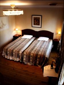 een slaapkamer met een bed met een dekbed en 2 lampen bij Hotell Mellanfjärden in Jättendal