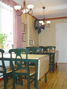 een eetkamer met groene stoelen en een tafel en een tv bij Hotell Mellanfjärden in Jättendal