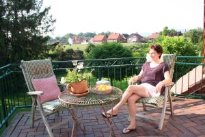 a woman sitting in a chair on a patio at Wunderschöne Landhauswohnung in Rinteln in Rinteln