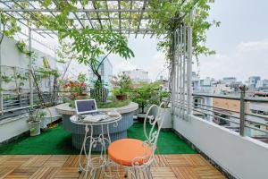 a balcony with a table and a laptop on it at Chez Mimosa Boutique - New address 135 Tran Hung Dao in Ho Chi Minh City