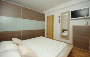 a bedroom with a white bed and a mirror at Apartment SeaSun in Makarska