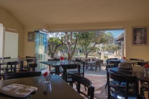 un restaurant avec des tables et des chaises et une terrasse dans l'établissement Ourania Apartments Hotel, à Gouves