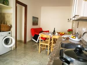 una cucina con tavolo e una sala da pranzo di Condominio Moschettieri trilocale a Bibione