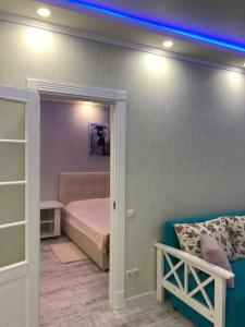 キーウにあるLuxe Apartment on Drahomanovaのベッドルーム1室(ベッド1台、青い照明付)