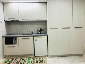 a kitchen with white cabinets and a sink at K&B Luxury Studios in Kavála +2 photos