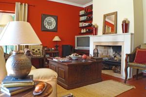 a living room with red walls and a fireplace at Casa Monserrat in Chamusca