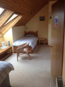 a bedroom with a bed and a chair in a room at Creag Na Mara B&B in Thurso