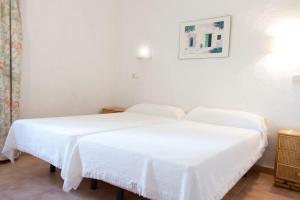 two beds in a room with white sheets at Casa Lulu in Marbella