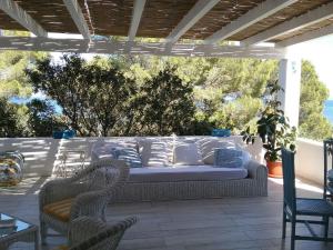 a couch on a patio with two chairs and a table at Villa Biancaluna in Carloforte