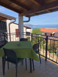 un tavolo verde e sedie su un balcone con vista di Verde Sea View Apartment 400 m from Beach - Free Parking a Ravni Altre 18 foto