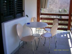a table and chairs on a balcony with a window at Vila Vuk in Plitvička Jezera