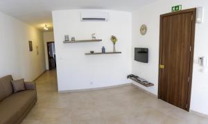 een woonkamer met een bank en een muur met planken bij Pierre & Liana's place in Msida