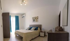 een slaapkamer met een bed met blauwe kussens bij Pierre & Liana's place in Msida