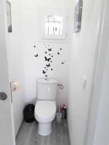 a bathroom with a toilet with butterflies on the wall at La Rivière in Pujols Gironde