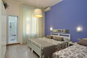 加提歐馬里的住宿－Hotel Roma，一间卧室设有两张床和蓝色的墙壁