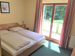 a bedroom with a bed and a large window at Hotel Scheid in Schriesheim