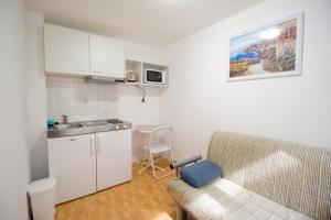 a living room with a couch and a kitchen at Apartmani Diki in Makarska