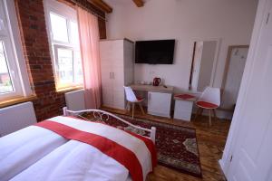 a bedroom with a bed and a table with chairs at Willa Starowiejska in Racibórz
