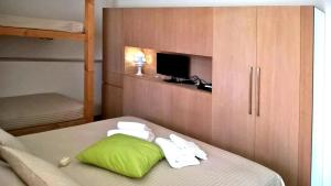 a bedroom with a bed with a green pillow and a cabinet at Alfieri Cottage in Ruvo di Puglia