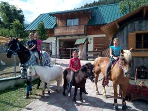 a group of children riding horses in front of a house at Appartment Iris in Aich